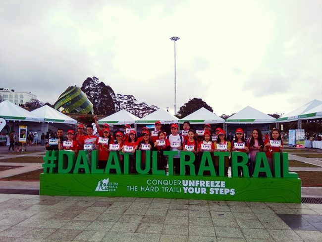 DALAT ULTRA TRAIL 2018: CÂU CHUYỆN TRUYỀN CẢM HỨNG ĐƯỢC VIẾT NÊN BỞI SOLARBK RUNNERSPhát huy tinh thần thể thao đã trở thành một nét văn hóa không thể thiếu tại SolarBK. Trong 2 ngày diễn ra giải siêu Marathon Quốc tế Dalat Ultra Trail 2018, sắc đỏ của SolarBK đã phủ sóng với gần 60 người tham gia tại 3 đường chạy 42 km, 21 km và 10 km. Nằm trong hệ thống giải chạy địa hình chuyên nghiệp châu Á - Asia Trail Master, Dalat Ultra Trail là giải chạy mang tầm vóc quốc tế ở khu vự c Tây Nguyên. Lộ trình thi đấu của giải đưa các vận động viên đi qua những địa danh nổi bật của thành phố Đà Lạt và tỉnh Lâm Đồng: quảng trường Lâm Viên, thung lũng Vàng, thung lũng Tình yêu, núi Langbian, vườn quốc gia Bidoup… Trước đó, SolarBK Runners cũng đã góp mặt tại nhiều giải Marathon trải đều trên khắp đất nước, có thể kể đến như giải Marathon Quốc tế Đà Nẵng, Spring Race, HCMC Run, Test Run, giải báo Vũng Tàu qua nhiều năm liên tiếp. Trải nghiệm qua mỗi chặng đường, các “vận động viên” đều cảm thấy như mình dần trưởng thành và bản lĩnh hơn. Không giống như những giải chạy đường bằng, Dalat Ultra Trail mang tính thử thách hơn rất nhiều cả về sức bền và khả năng chịu đựng thời tiết thất thường tại Đà Lạt. Để tham gia giải chạy lần này, các “SolarBK Runners” đã cùng nhau tự tổ chức những buổi luyện tập trước đó nhằm đáp ứng nền tảng thể lực cho cuộc đua đầy thử thách phía trước, khắc nghiệt từ điều kiện thời tiết, khí hậu cho đến địa hình. Trời đổ mưa lớn trong buổi lễ khai mạc Dalat Ultra Trail vẫn không làm nản lòng tinh thần thi đấu của các SolarBK Runners Trong buổi lễ khai mạc, Đà Lạt đón các SolarBK Runners bằng những cơn mưa nặng hạt, không khí ẩm ướt lạnh buốt đã phần nào ảnh hưởng đến thể trạng của nhiều vận động viên nữ, vốn đã quen với cái nắng ấm áp của Sài Gòn. Tuy vậy, cả tập thể vẫn sung sức và tràn đầy hứng khởi, đúng với tinh thần của một công ty làm về năng lượng. Sắc đỏ SolarBK làm cho không khí buổi lễ khai mạc thêm tưng bừng, rộn ràng Trong ngày đầu tiên ra quân, các runners cũng không kém phần ấn tượng khi đưa nguyên đội hình “cổ vũ” đến khu vực tập kết của đường chạy 42km và 21km. Đây đều là các cô gái, chàng trai đăng ký đường chạy 10km vào ngày hôm sau. Cái lạnh buốt của Đà Lạt sáng sớm không thể làm hạ nhiệt bầu không khí rực “lửa” màu cờ mang tên SolarBK. Dù bị lạc đường và đến trễ hơn so với dự định, các cổ động viên SolarBK vẫn nhanh chóng vào vị trí, cổ vũ cho đội xuất phát ở đường chạy 42km đầy thử thách Xuất phát từ 4h sáng để đến điểm tập kết, các vận động viên tham gia đường chạy 42km phải mất gần 9 tiếng để về đến đích, vượt qua những ngọn đèo, băng suối, leo dốc dưới cái lạnh đầy sương buổi sớm và nắng gắt khi về trưa. Đã có lúc, đôi chân mỏi mệt, căng cơ đến chuột rút, nhưng sự kiên trì và hỗ trợ lẫn nhau trong suốt chặng đường đã giúp hai vận động viên của SolarBK về đích trong niềm vui, sự reo hò, cổ vũ tinh thần rất lớn từ phía cổ động viên SolarBK. Vượt qua chặng đường 42km chỉ là chuyện nhỏ, vượt qua chính mình là điều quan trọng hơn cả. Cảm động trước tinh thần đoàn kết của SolarBK trong đợt ra quân 42km, ban tổ chức đã mời các cô gái tiếp tục trình diễn tiết mục trực tiếp ngay vạch xuất phát, cổ vũ tinh thần cho những vận động viên 21km. Ở đường đua này, SolarBK cũng góp mặt với 2 chàng trai. Màu đỏ SolarBK thổi bùng năng lượng cho các tuyển thủ 21km trước giờ xuất phát Đã trải qua những tháng ngày làm bạn với nắng, gió Trường Sa trong những chuyến công tác lắp đặt hệ thống năng lượng sạch tại đây, nên đường đua này đối với hai anh tương đối nhẹ nhàng. Cả hai đều hoàn thành chặng đường với thời gian ấn tượng, vượt lên cả sự chờ đợi từ các “fan” SolarBK. Hai vận động viên đã giữ lá cờ được giao từ lúc xuất phát để giơ cao trong khoảnh khắc về đích, thể hiện màu cờ sắc áo SolarBK Sau khi hoàn thành xuất sắc ở hai chặng đường 42km, 21km, SolarBK Runners tiếp tục bước vào chặng đường 10km với lực lượng tham gia áp đảo. Sắc đỏ một lần nữa “chiếm sóng” ngay trước giờ xuất phát. Dù ngày trước đó, các tuyển thủ 10km trong vai trò cổ động viên đã hoạt động hết công suất để cổ vũ cho đồng đội, mọi người vẫn trông thật khỏe khoắn và tràn đầy năng lượng . SolarBKers đã nạp đầy năng lượng, sẵn sàng cho thử thách tiếp theo Trong chặng đường lần này, các cô gái SolarBK chiếm tỷ lệ áp đảo. Có khá nhiều người mới bước vào tham gia thể loại Marathon lần đầu tiên nên kinh nghiệm chạy bộ lẫn thể lực đều hạn chế. Hơn nữa, thử thách lớn nhất đặt ra ở những đường đua cuối cùng, với con dốc dài gần 1km, nắng gắt cùng đôi chân đã mệt nhoài. Nhưng cũng chính tại đây, mọi người mới chứng kiến rõ nhất tinh thần, sự kiên cường của những SolarBKers và đặc biệt là tinh thần đồng đội đầy cảm động. Người đến trước cổ vũ cho người đến sau, sắc đỏ nhuộm rợp trời hai bên đường để tiếp thêm động lực, mọi người cùng dìu nhau đến đích và cùng nhau chiến thắng chính mình. Dù bị chuột rút, chàng trai vẫn về đích đầy tự hào với sự hỗ trợ của đồng đội Con dốc “huyền thoại” và sự ủng hộ tinh thần rất lớn từ những người anh em Chị Võ Thị Nhật Minh, tham gia đường chạy 10km cho biết: “Trước cuộc thi, tôi đã rất lo lắng vì mấy ngày trên Đà Lạt không ăn uống, sinh hoạt đầy đủ. Tôi lại là người ăn chay trường nên rất dễ mất sức và mới chỉ tham gia chạy địa hình lần đầu. Tuy vậy, trong quá trình chạy, tôi luôn có những đồng đội bên cạnh hỗ trợ và động viên. Việc về đích lần này có ý nghĩa rất lớn, nó giúp tôi cảm thấy tự tin hơn vào chính bản thân mình, cũng như trân trọng hơn tình đồng đội, tình bạn mà tôi đã may mắn có được khi làm việc tại SolarBK.” Chị Minh (ở giữa) cùng những đồng đội SolarBK trong khoảnh khắc tham gia đường chạy Hành trình tại Dalat Ultra Trail đã kết thúc, nhưng hành trình tại SolarBK và của mỗi chúng ta vẫn còn rất dài. Chỉ mấy ngày nữa thôi, những đôi chân SolarBK Runners lại tiếp tục sải bước chinh phục đường chạy Resolution tại Phú Mỹ Hưng, Quận 7. “Khi còn ngồi ghế nhà trường, tôi luôn thích môn chạy nhanh. Nhưng khi bước vào SolarBK, tôi bắt đầu thích môn chạy bền. Và tôi hiểu rằng, chạy bền giúp tôi sống bản lĩnh và có trách nhiệm hơn, biết vạch ra mục tiêu và biết kiên trì, nỗ lực từng ngày để hoàn thiện bản thân mình. Có lẽ, đây cũng chính là lý do mà công ty luôn tạo điều kiện để mỗi nhân viên tham gia, khi có giải chạy Marathon tổ chức” – Một SolarBKer tham gia giải chạy Dalat Ultra Trail chia sẻ. 